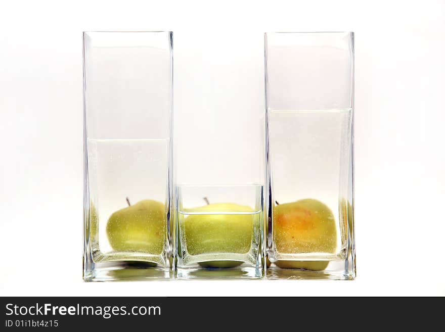 Glass transparent vases and green apples