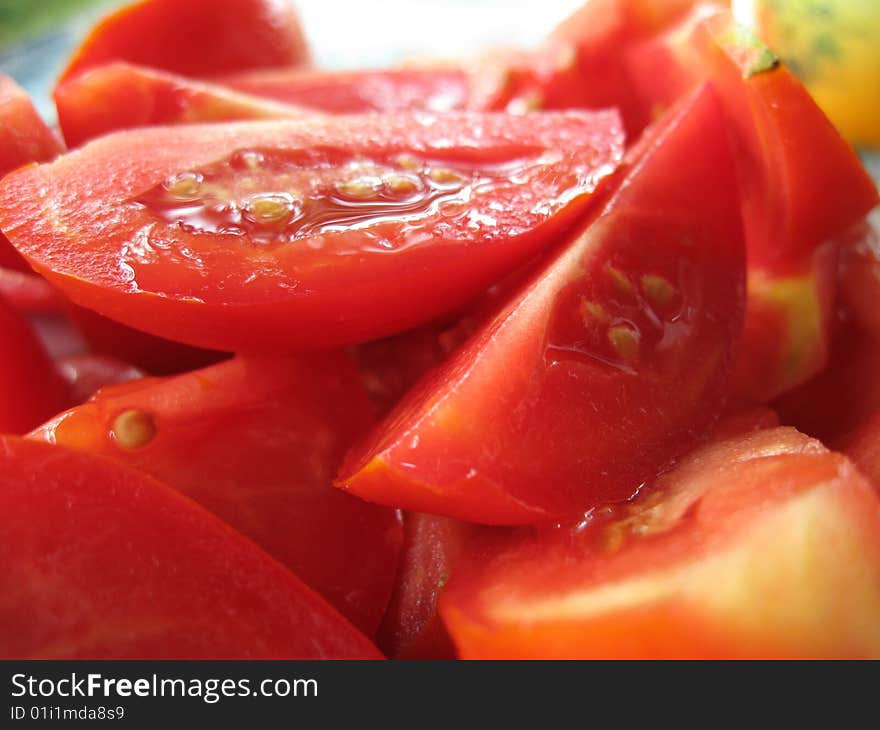 The tasty juicy tomatoes cut on a plate. The tasty juicy tomatoes cut on a plate