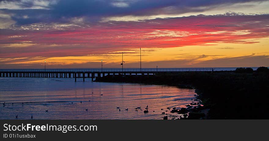 A beautiful beach sunset / sunrise with over a wooden pier