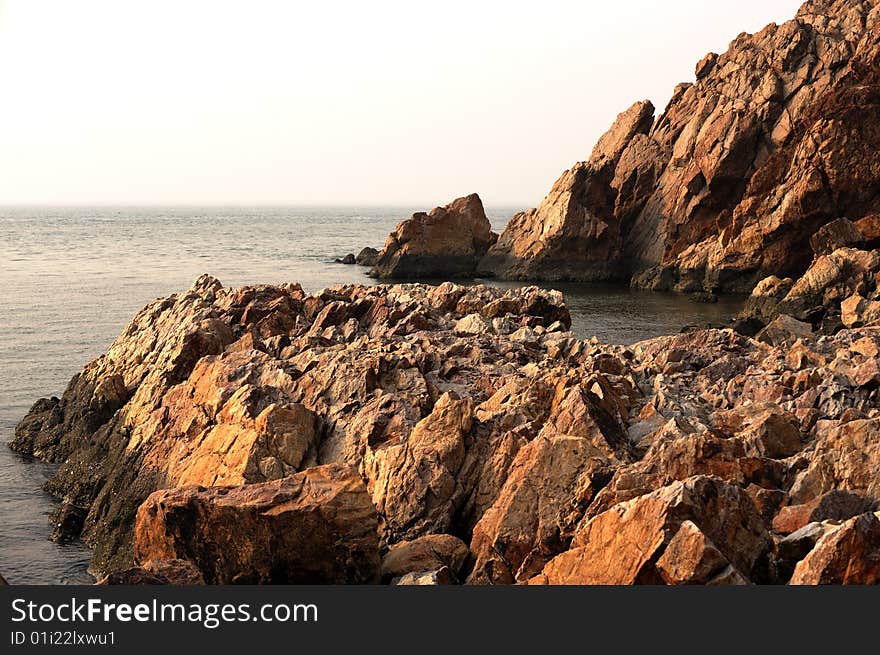 Red rock on side of sea