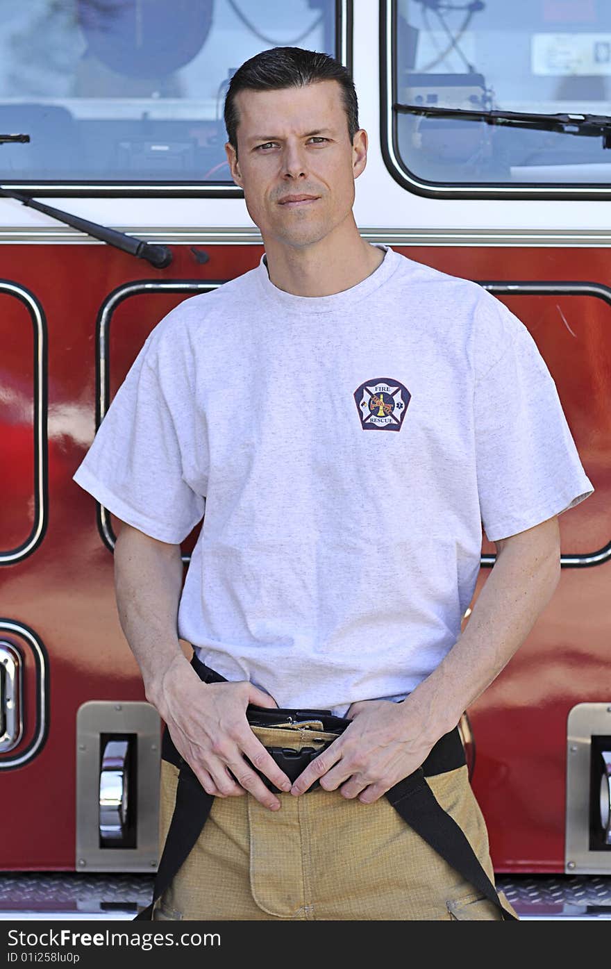 A fireman stands in front of fire truck. A fireman stands in front of fire truck