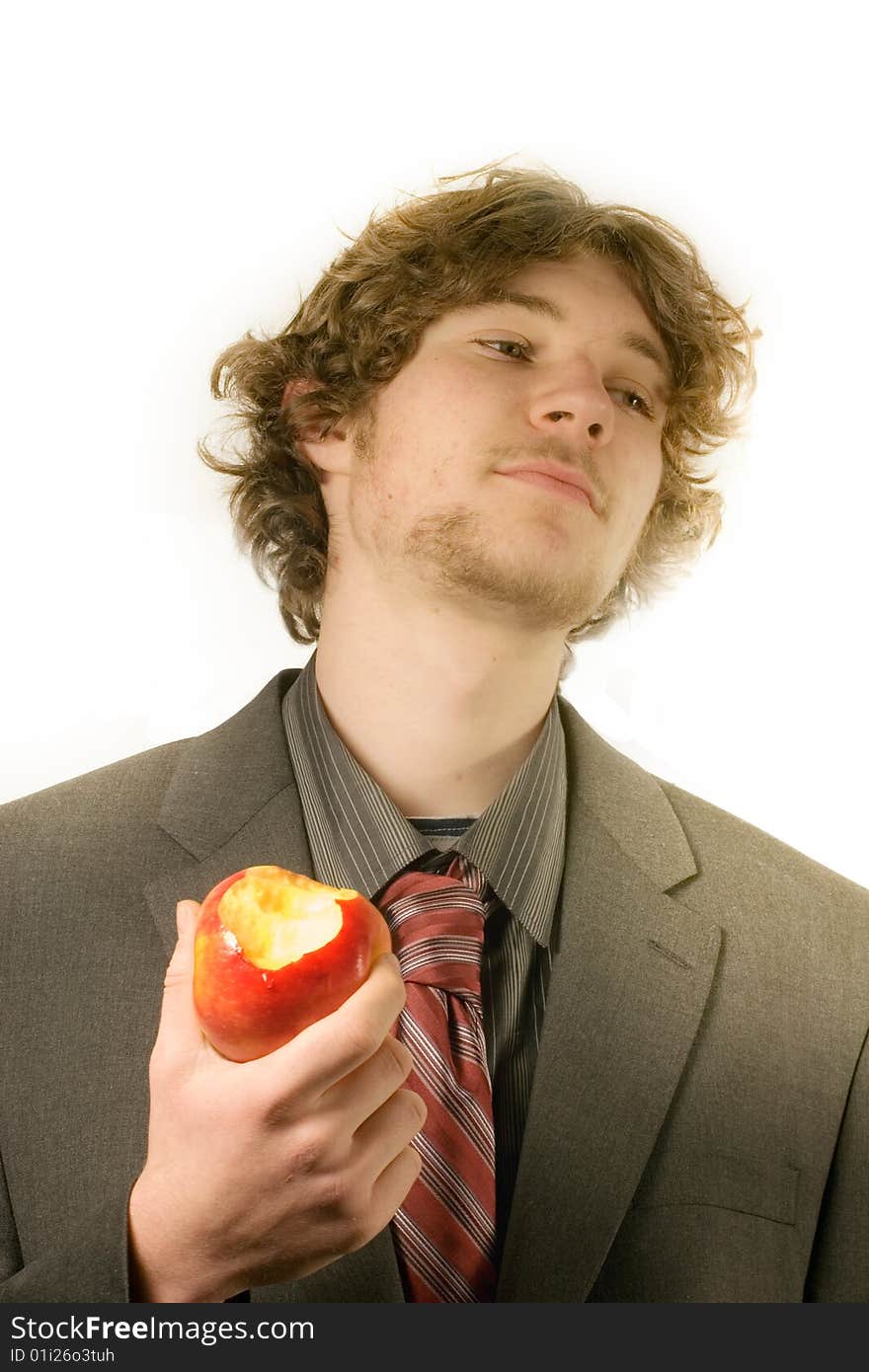 Young man in a business suit eating a red apple. Young man in a business suit eating a red apple