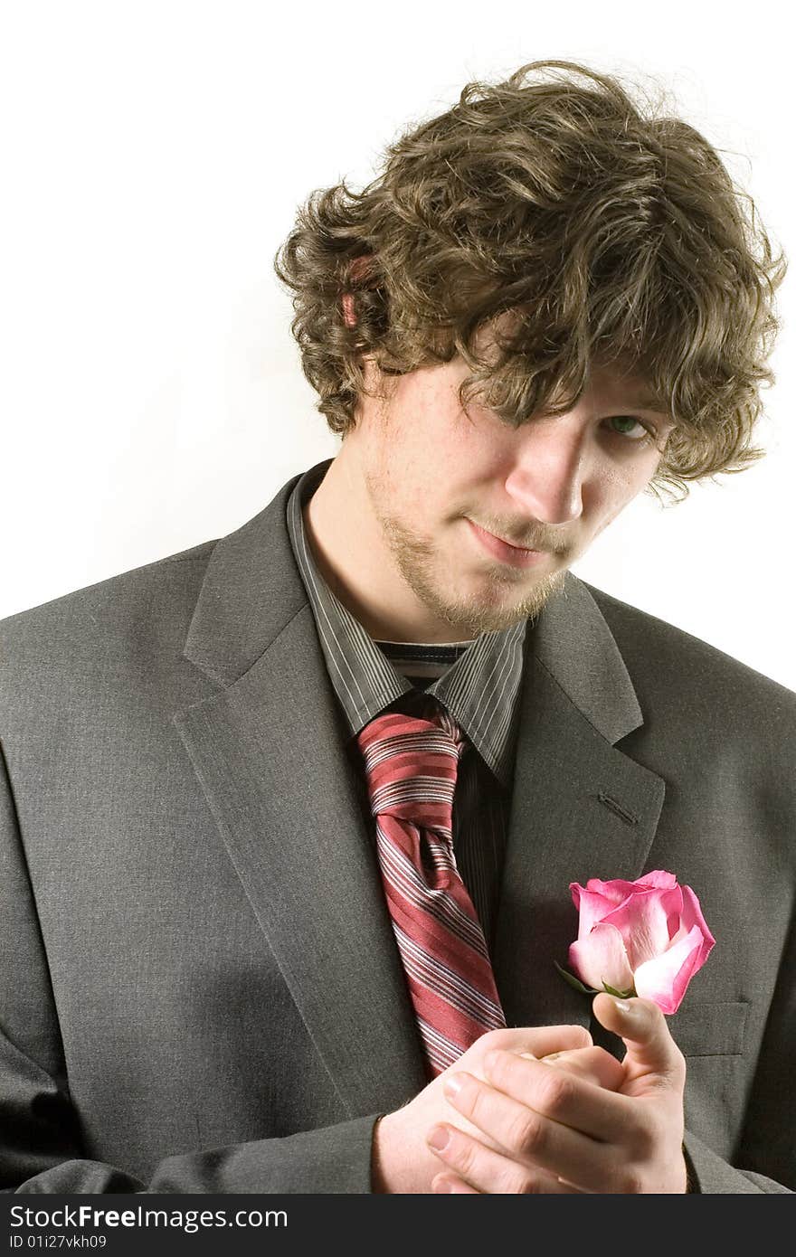 Young man in a romantic mood with a rose  in his hands, isolated on white. Young man in a romantic mood with a rose  in his hands, isolated on white