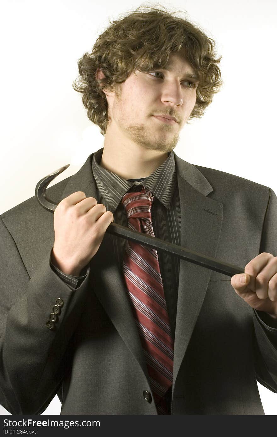 Young man in a business suit, holding a crowbar, either breaking something, or defending himself. Young man in a business suit, holding a crowbar, either breaking something, or defending himself.