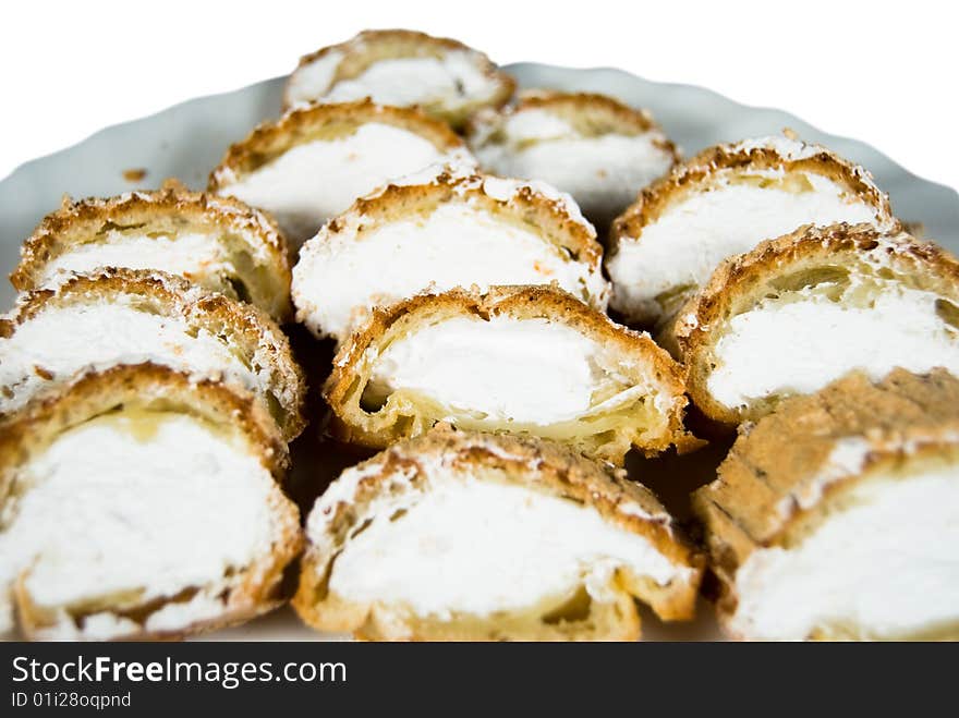 Cake with custard on plate on white background