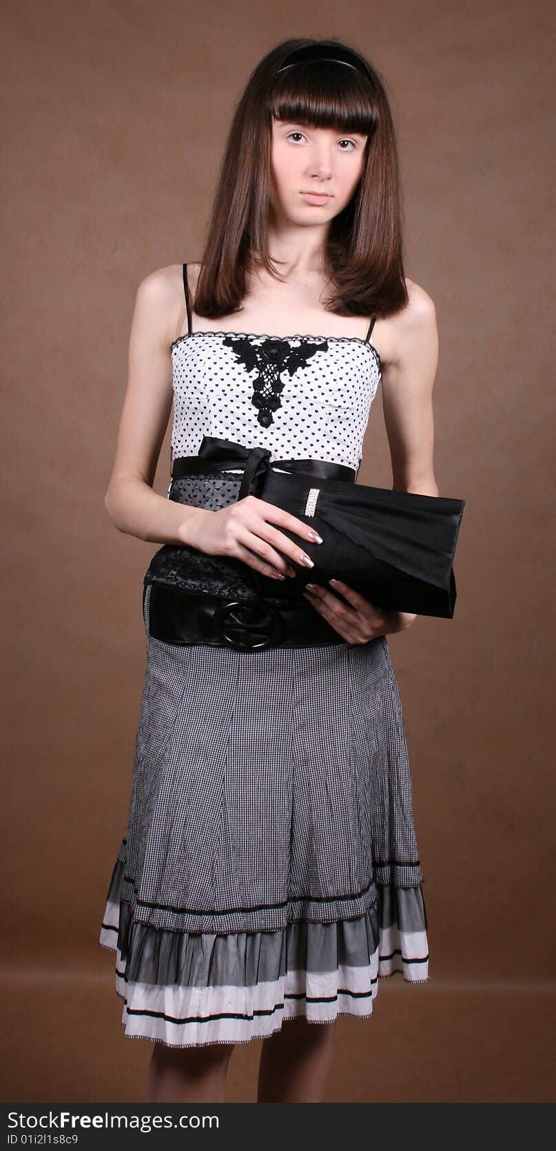 Graceful girl with a lady bag in studio