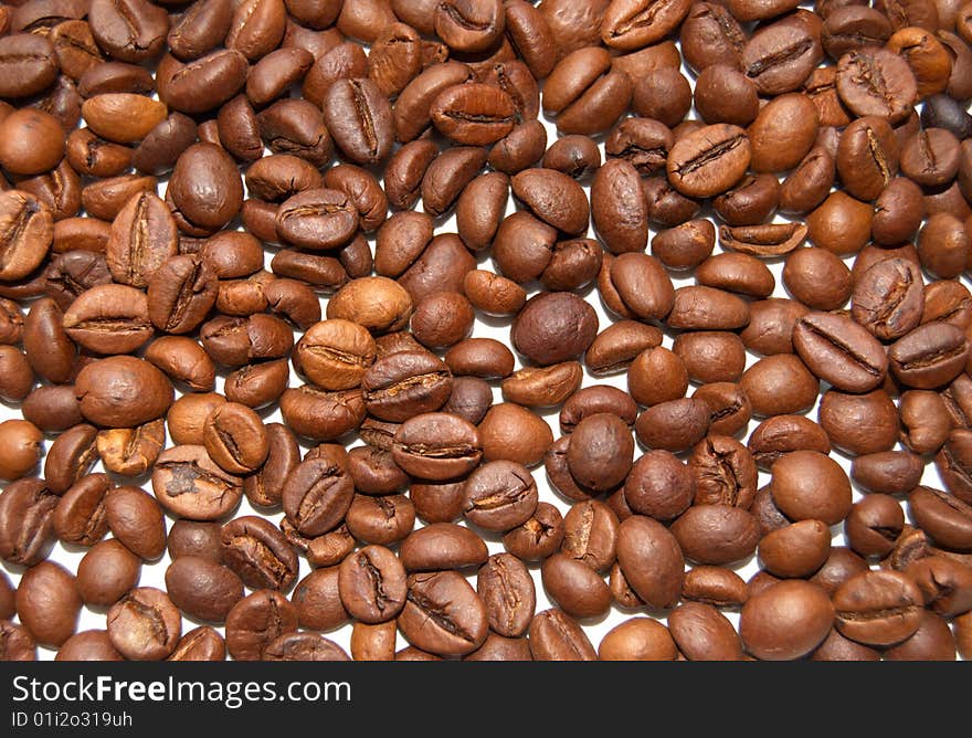 The textural background which has been laid out from brown grains of coffee. The textural background which has been laid out from brown grains of coffee.