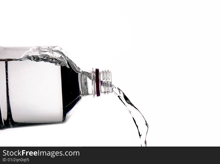 Pouring water from a bottle on white background