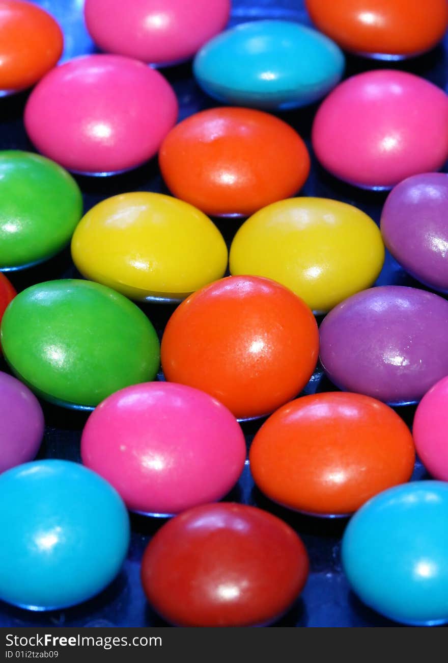 A pile of chocolate candies with a colorful outer shell