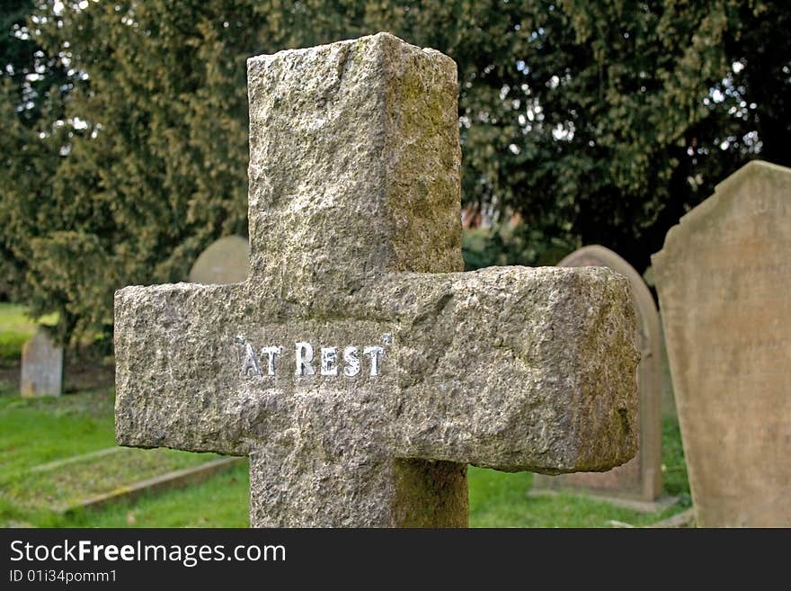 Cross Gravestone in a cemetery with other gravestones in the background