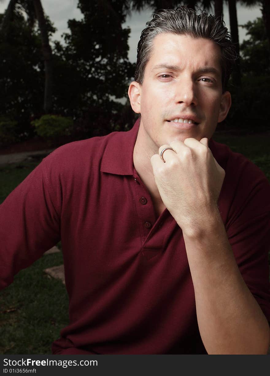 Young man posing with his hand on his chin. Young man posing with his hand on his chin