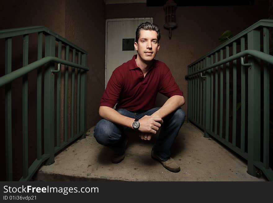 Young businessman squatting on a staircase