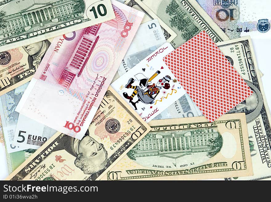 Mixed banknotes as background with two cards - jokers. Photo of different banknotes, money in different shapes and colors. Useful for financial, economic backgrounds. Mixed banknotes as background with two cards - jokers. Photo of different banknotes, money in different shapes and colors. Useful for financial, economic backgrounds.