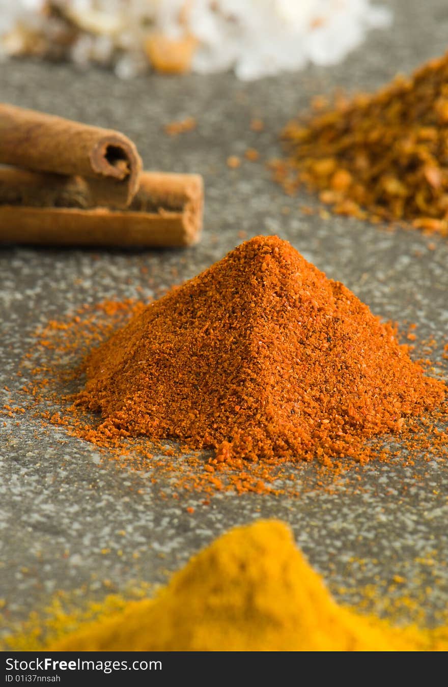 Piles of ground spices on grey background