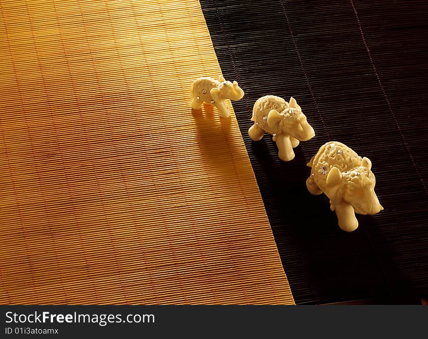 Three elephant toys on a mat