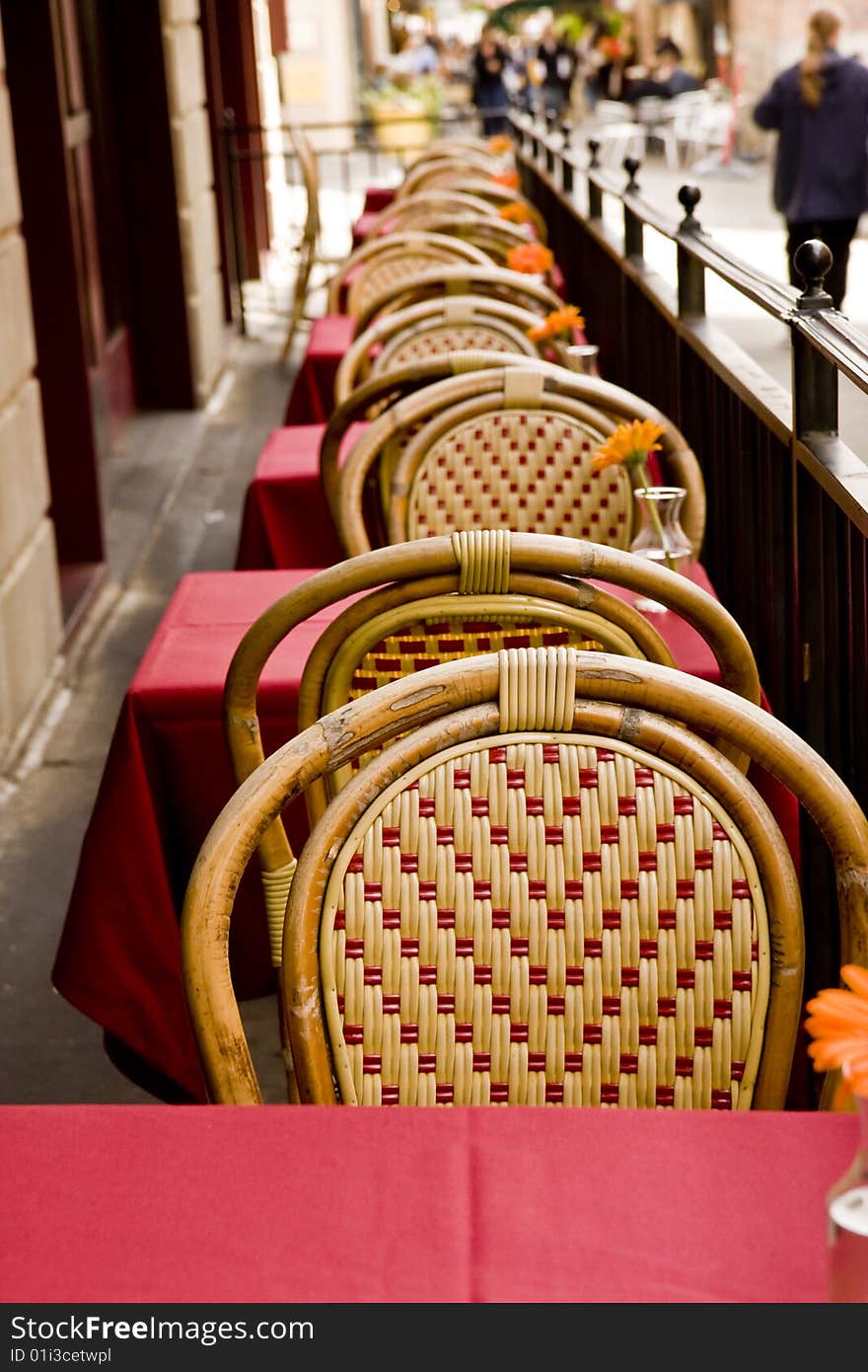 Tables and chair at an outside cafe with orange flowers. Tables and chair at an outside cafe with orange flowers