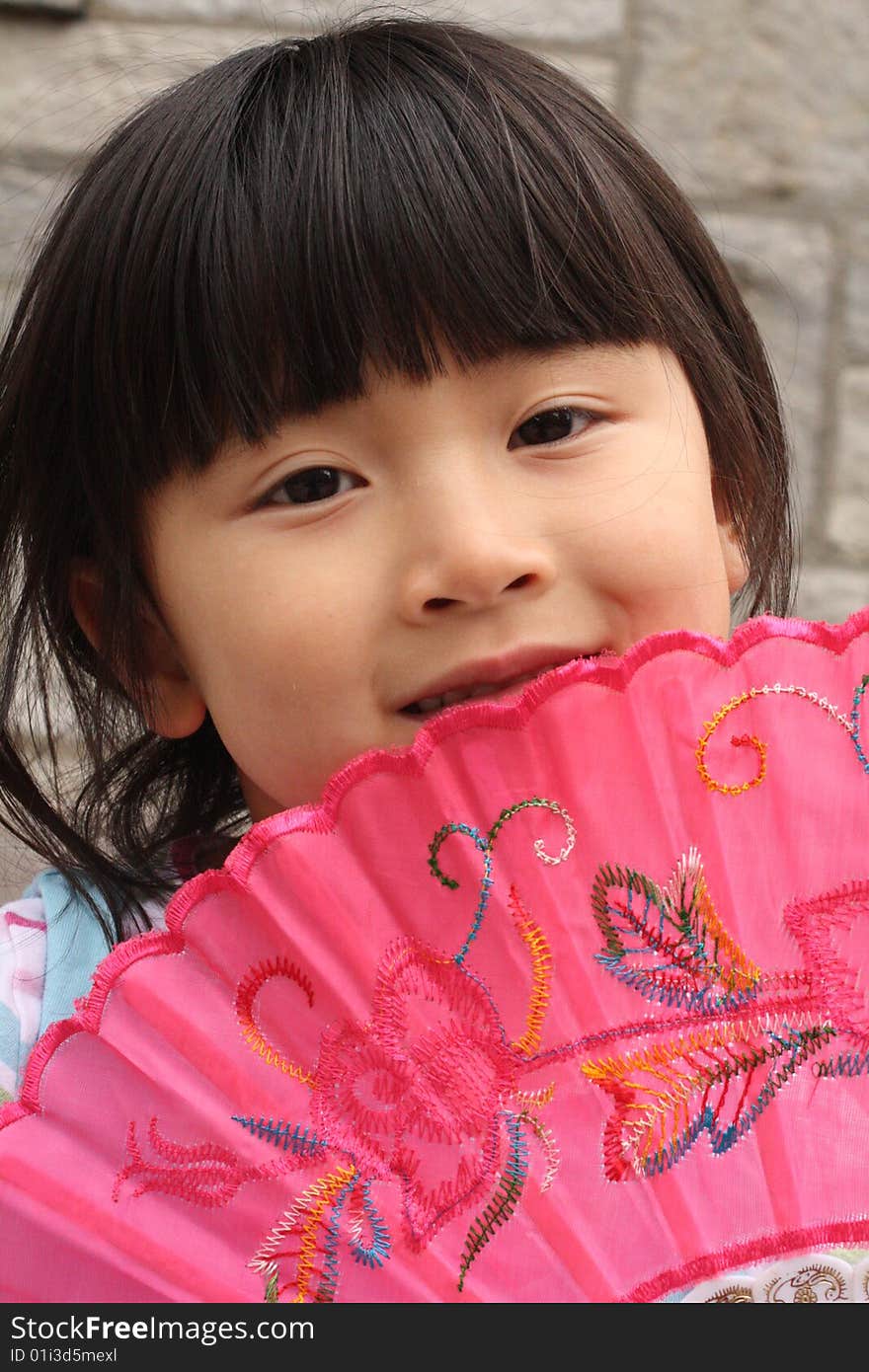 Chinese Girl holdling Pink Fan Up To Her Face. Chinese Girl holdling Pink Fan Up To Her Face