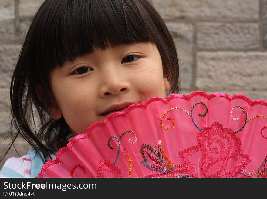 Asian Chinese Girl with Pink Fan up to her Face. Asian Chinese Girl with Pink Fan up to her Face