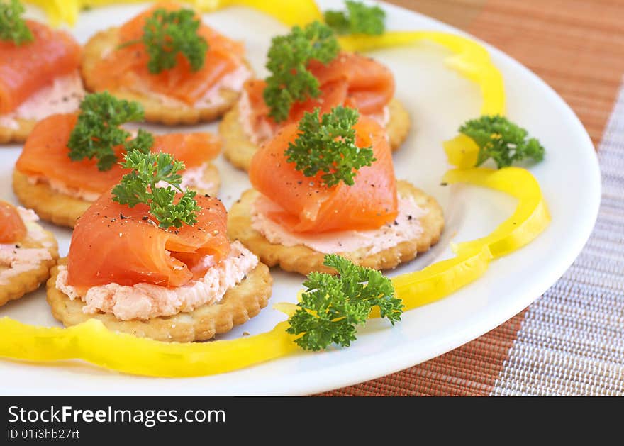 Smoked salmon and cream cheese on mini crackers with freshly cracked black pepper and garnishing of parsley. Smoked salmon and cream cheese on mini crackers with freshly cracked black pepper and garnishing of parsley