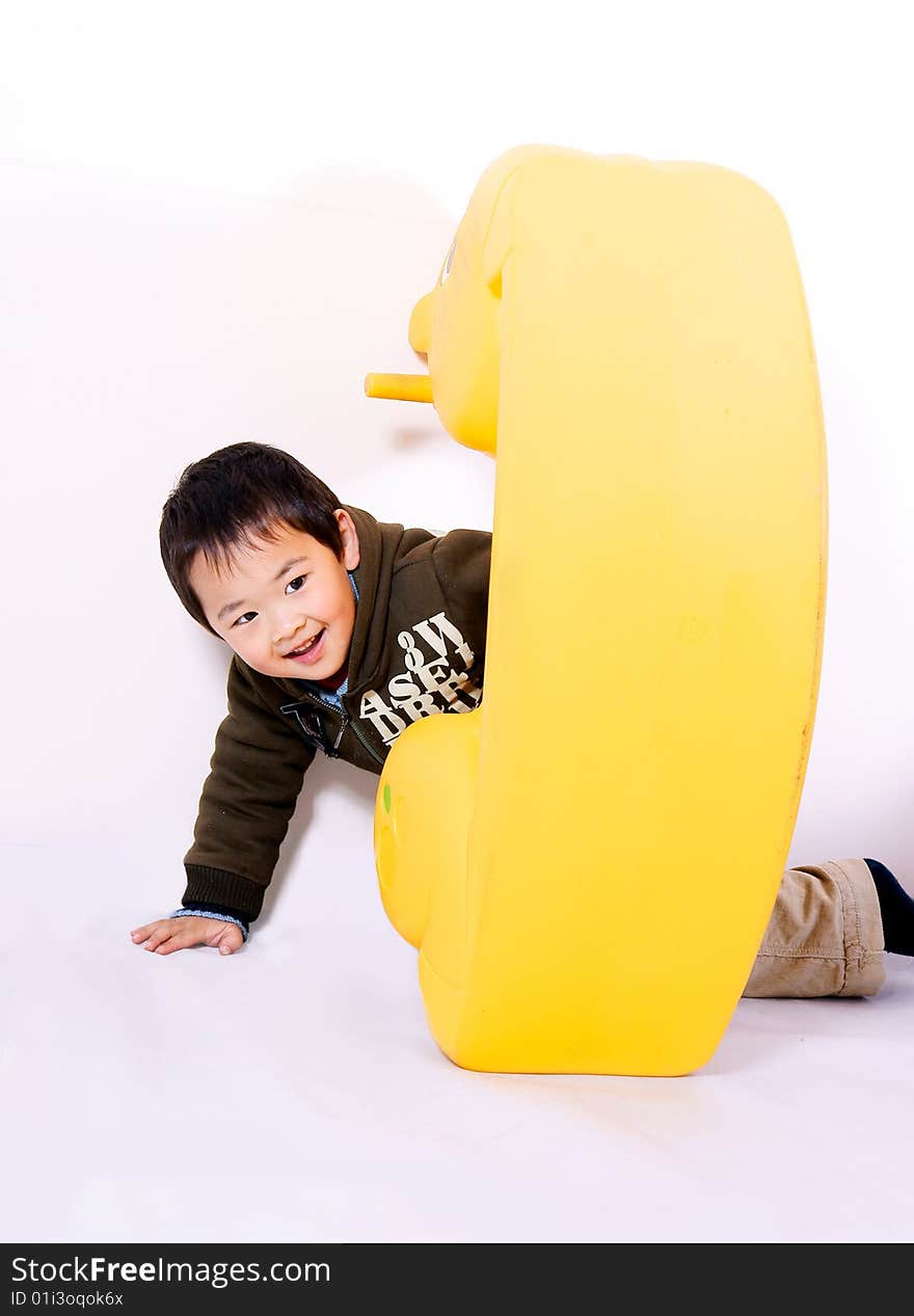 A picture of a little chinese boy playing with toy horse and having great fun