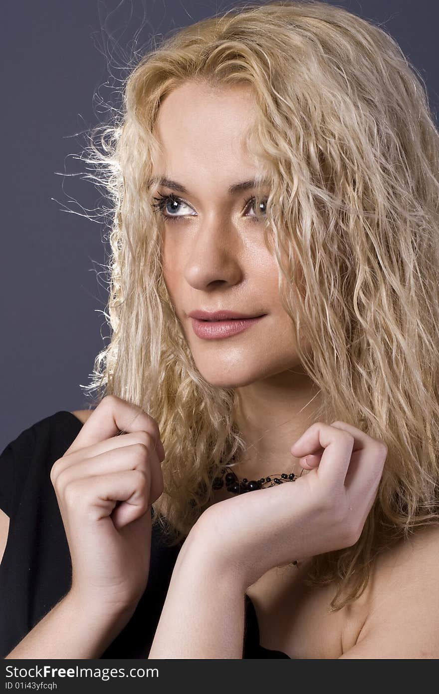 Beautiful curly blond girl with black dress and necklace portrait. Beautiful curly blond girl with black dress and necklace portrait