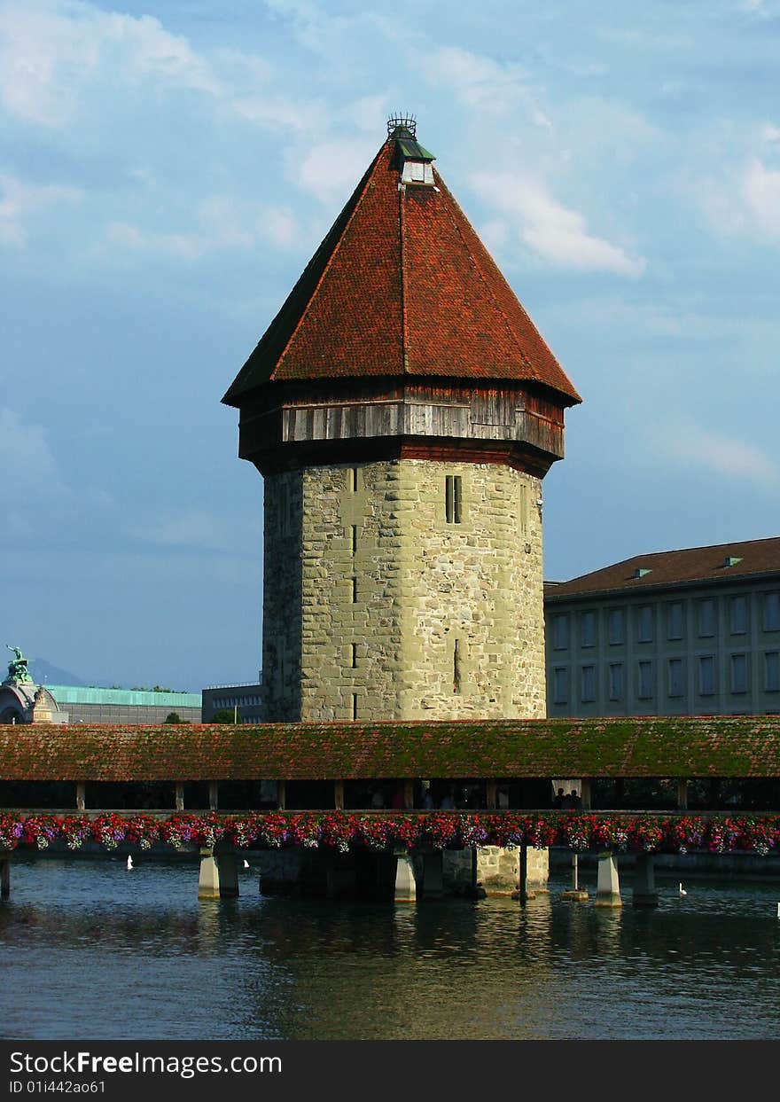 The Chapel Bridge (Kapellbr�cke) in Lucerne, Switzerland is a 204 m (670 ft) long wooden bridge originally built in 1333, although much of it had to be replaced after a fire on August 18, 1993, allegedly caused by a cigarette that was thrown away. Partway across, the bridge runs by the octagonal Water Tower (Wasserturm), a fortification from the 13th century. The Chapel Bridge (Kapellbr�cke) in Lucerne, Switzerland is a 204 m (670 ft) long wooden bridge originally built in 1333, although much of it had to be replaced after a fire on August 18, 1993, allegedly caused by a cigarette that was thrown away. Partway across, the bridge runs by the octagonal Water Tower (Wasserturm), a fortification from the 13th century.