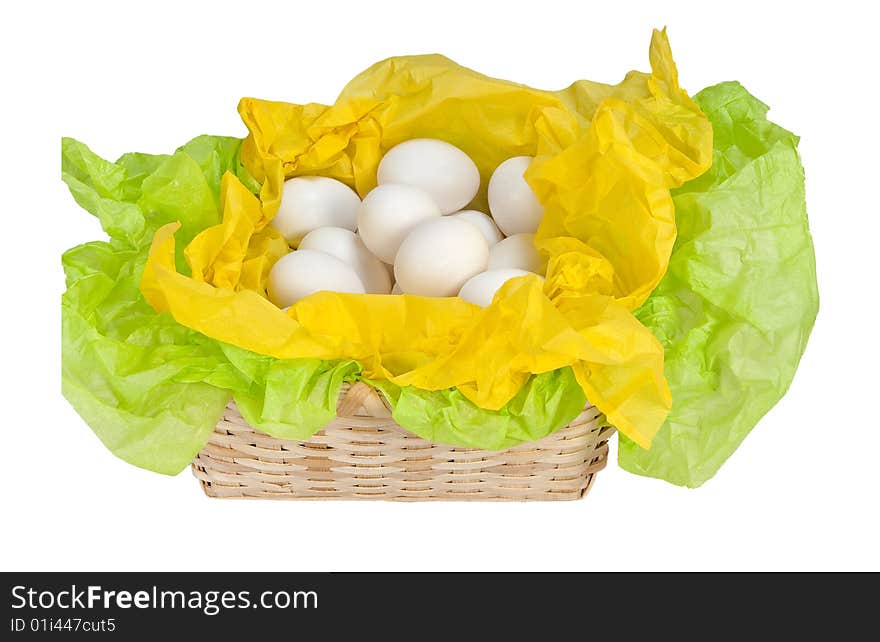 Natural basket with eggs and tissue paper in green and yellow. Natural basket with eggs and tissue paper in green and yellow.