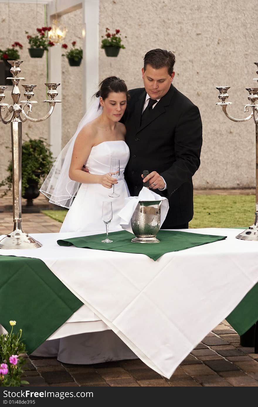 Newlyweds getting bottle ready for toasting. Newlyweds getting bottle ready for toasting