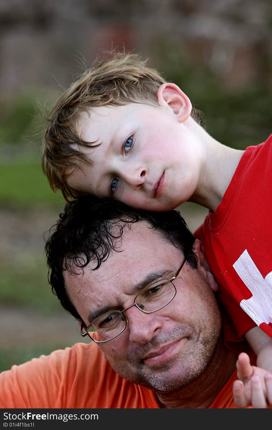 Young son leaning onto his father. Young son leaning onto his father