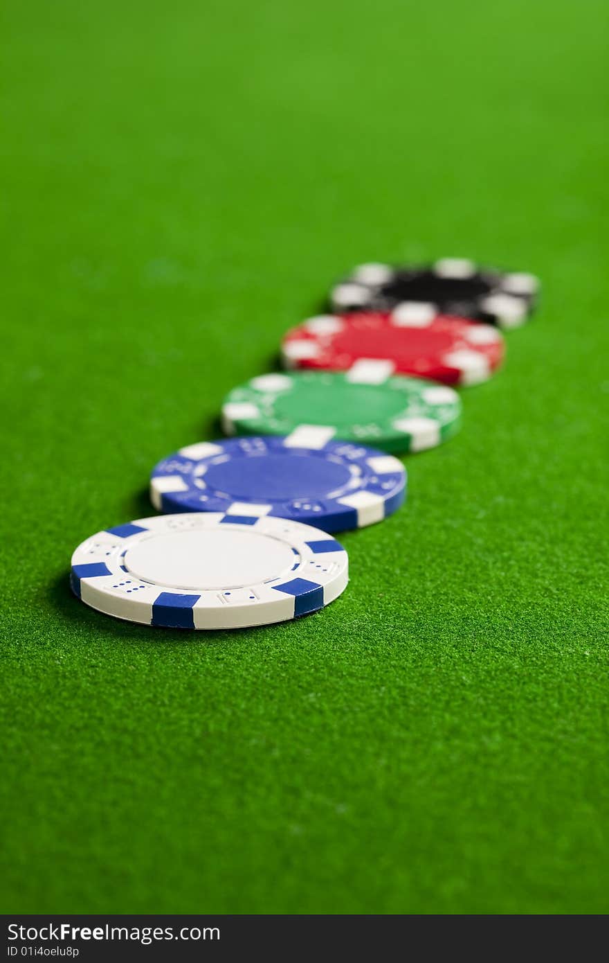 Blank casino chips on the green gaming table