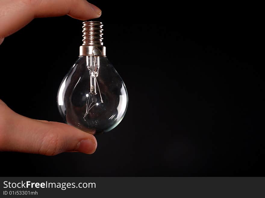 Electric lamp in male fingers