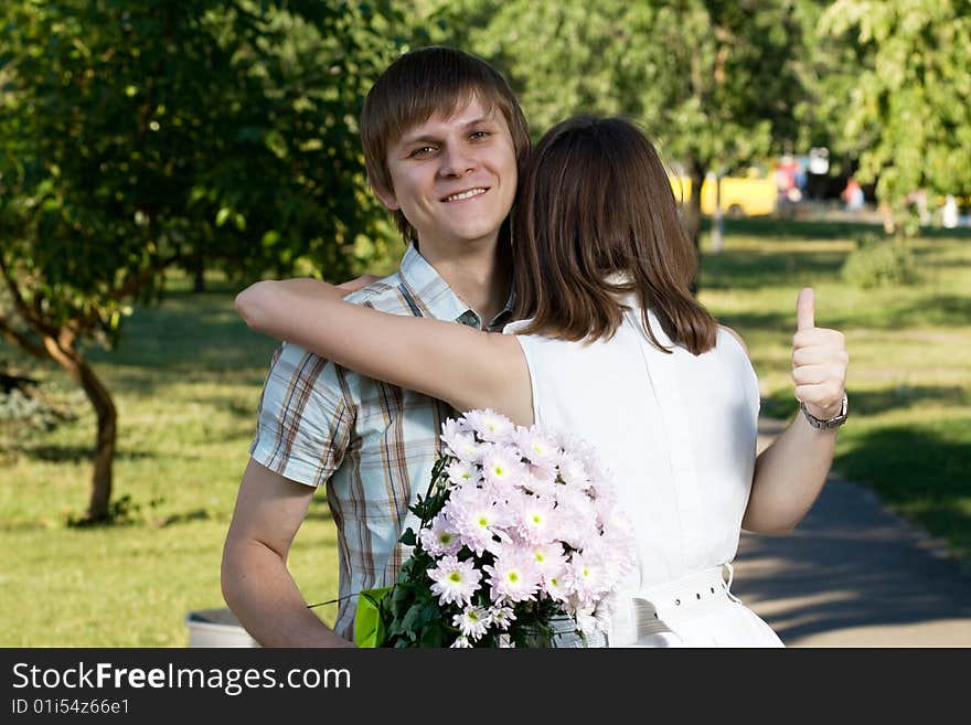 A lovely teen couple is having a date in a park. The boy is very happy about it. A lovely teen couple is having a date in a park. The boy is very happy about it.