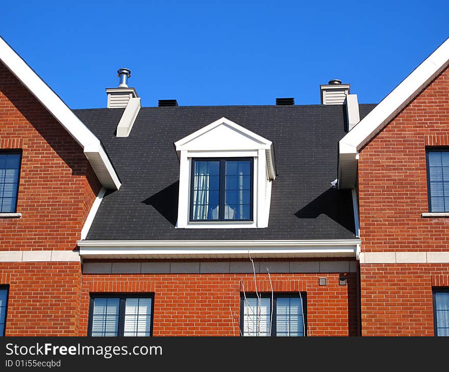 Rooftops of town homes with a blue sky