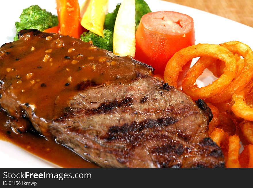 Steak with vegetables and curly fries