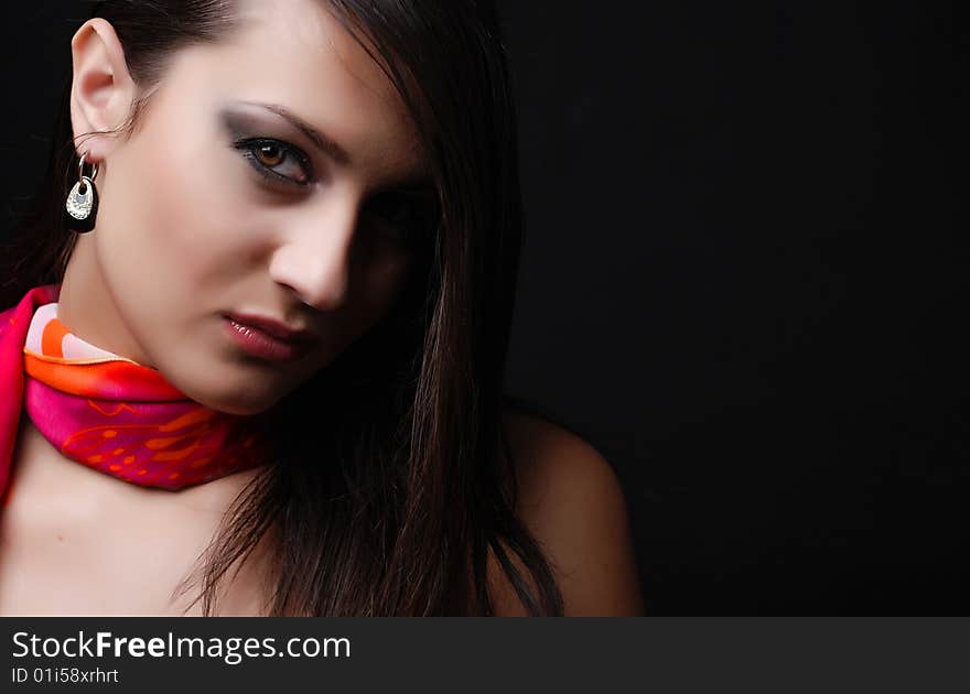 Beautiful brunet woman in red scarf at black background. Beautiful brunet woman in red scarf at black background