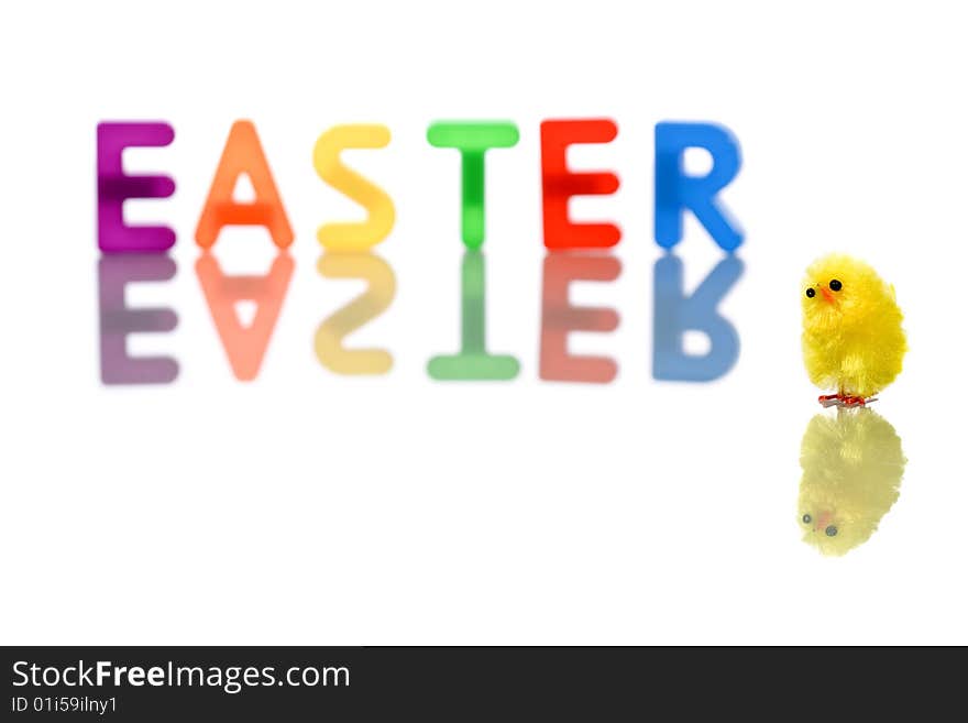 Baby chick reflected in white with colorful easter word in background