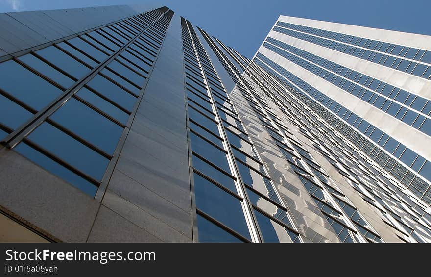 Looking up and up along the sides of a couple of skyscrapers.