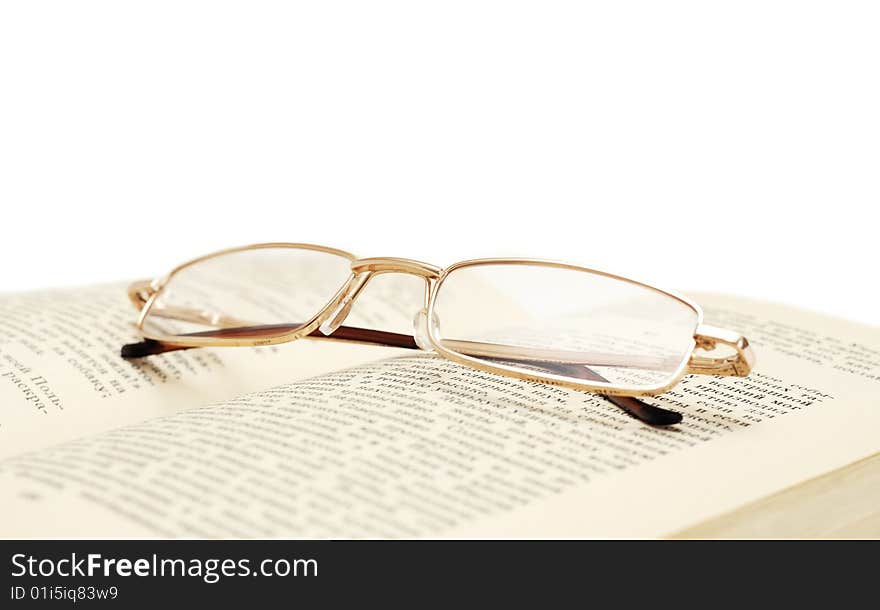 Glasses on book isolated on white