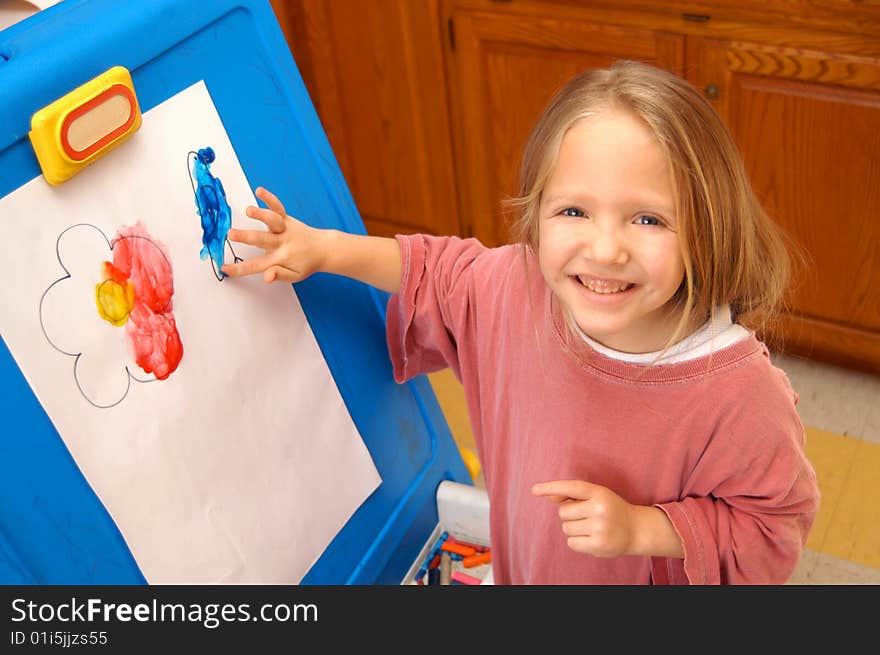 Exploring her creativity, a young girl spends part of her day finger painting.