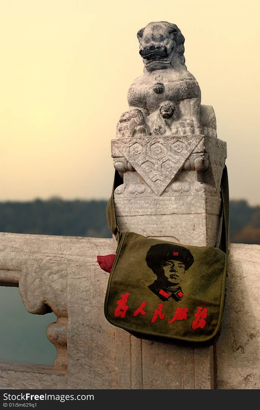 A old Satchel was hung on a statue of stone lion. A old Satchel was hung on a statue of stone lion.