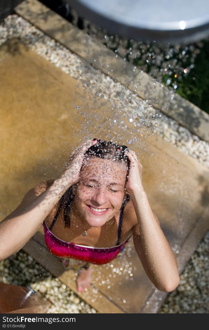 Young girl in the outdoor shower is smiling