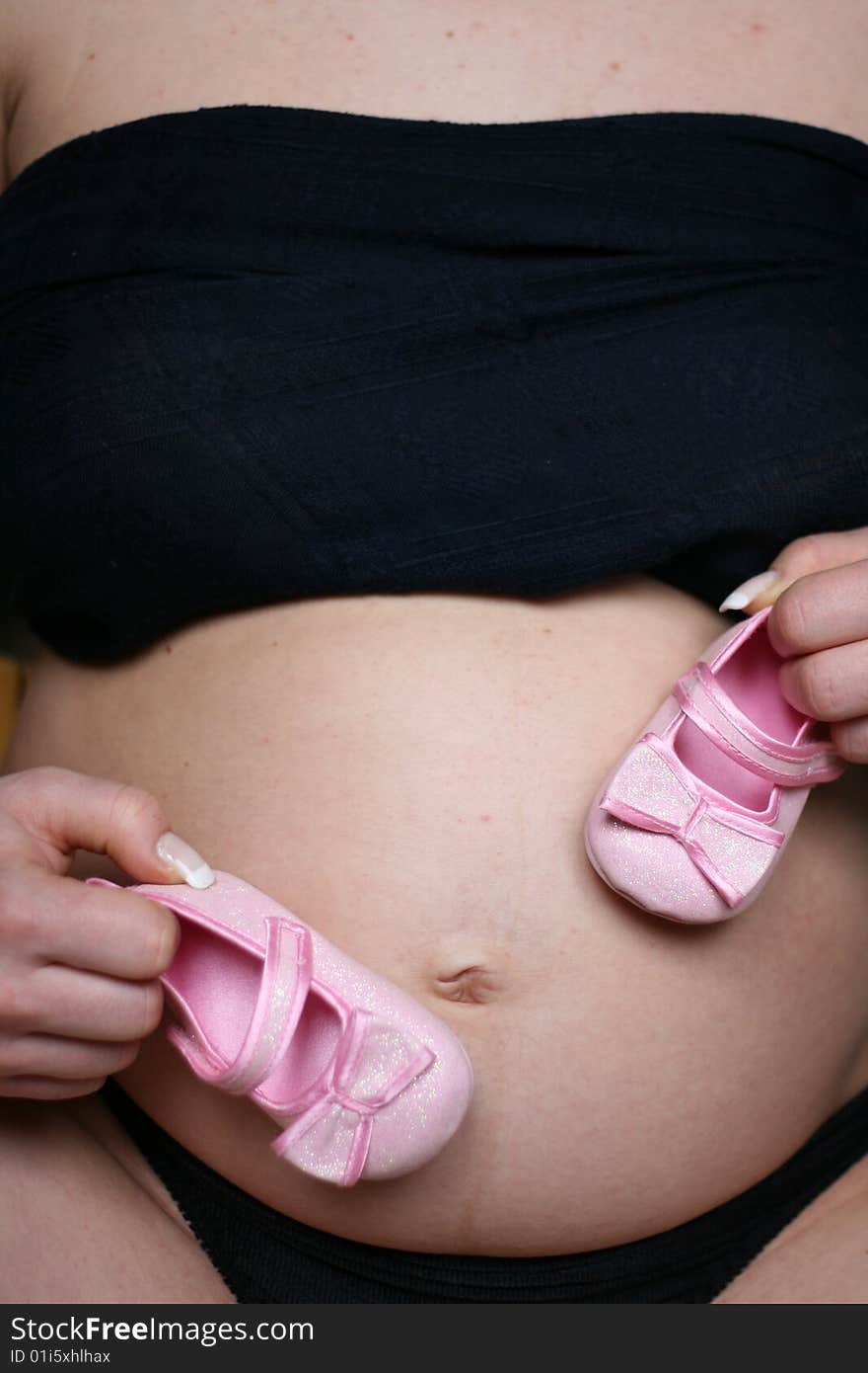 Pregnant woman with pink small shoes. Pregnant woman with pink small shoes.