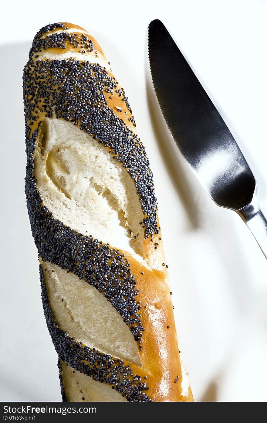 Poppy bread with knife on a white place