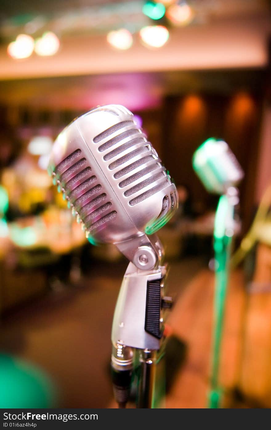 Vintage microphone, blurred club interior on background