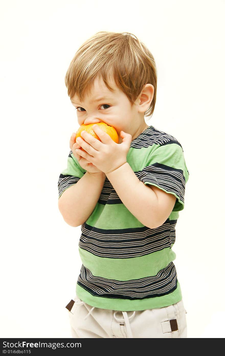 Young boy eating orange over white