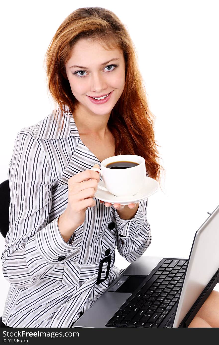 Young business woman with a laptop and drinking coffee. Young business woman with a laptop and drinking coffee