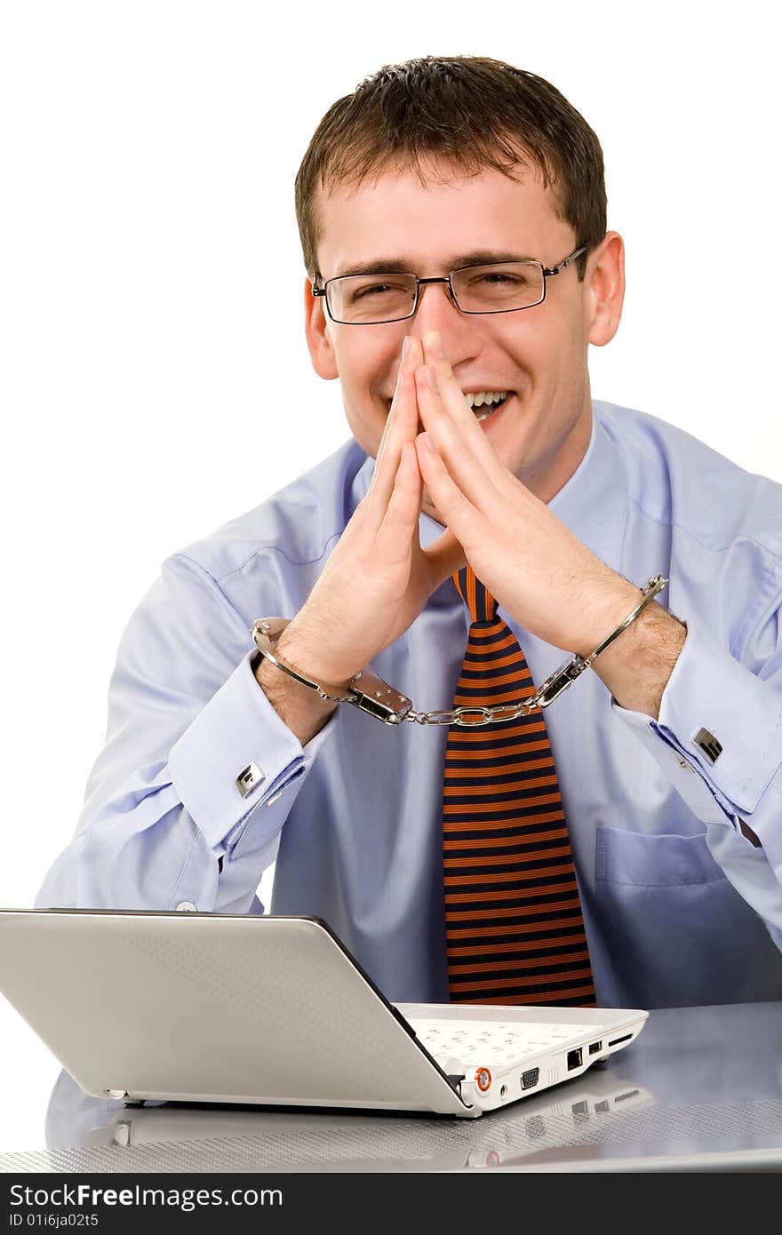 Handsome young businessman bound to laptop with handcuffs. Handsome young businessman bound to laptop with handcuffs