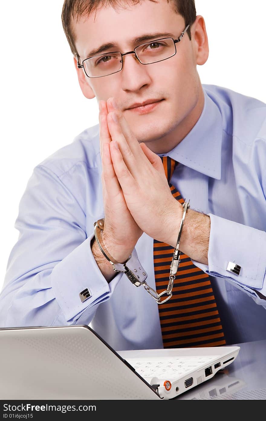 Handsome young businessman bound to laptop with handcuffs. Handsome young businessman bound to laptop with handcuffs