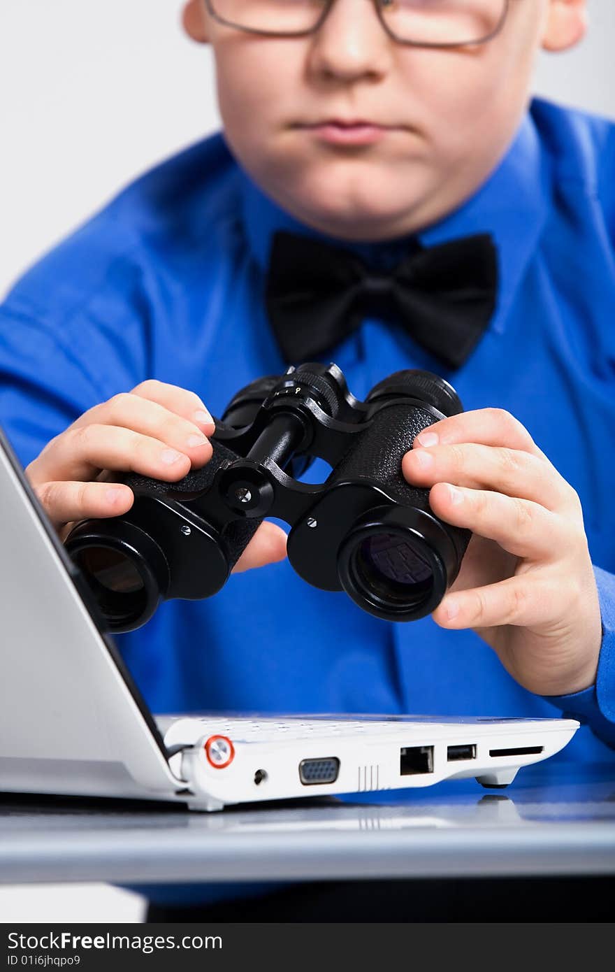 Joyful boy looking at computer screen in binoculars