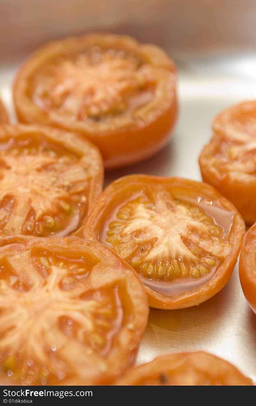 Grilled tomatoes in oven tray. Selective focus, vertical composition. Grilled tomatoes in oven tray. Selective focus, vertical composition.